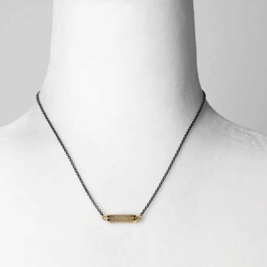 Necklace with a gold bar pendant on a mannequin against a white background