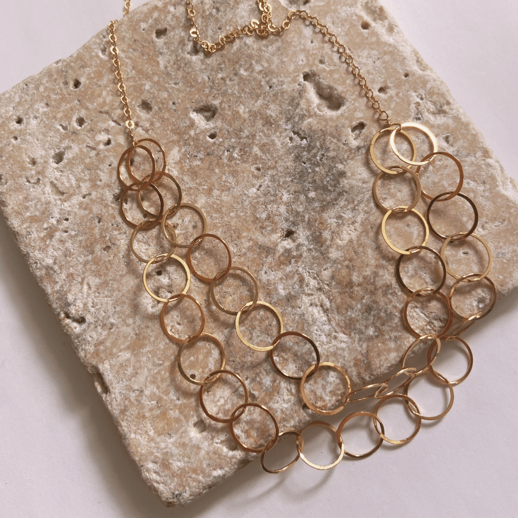 Gold chain necklace on a textured stone surface