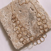 Gold chain necklace on a textured stone surface
